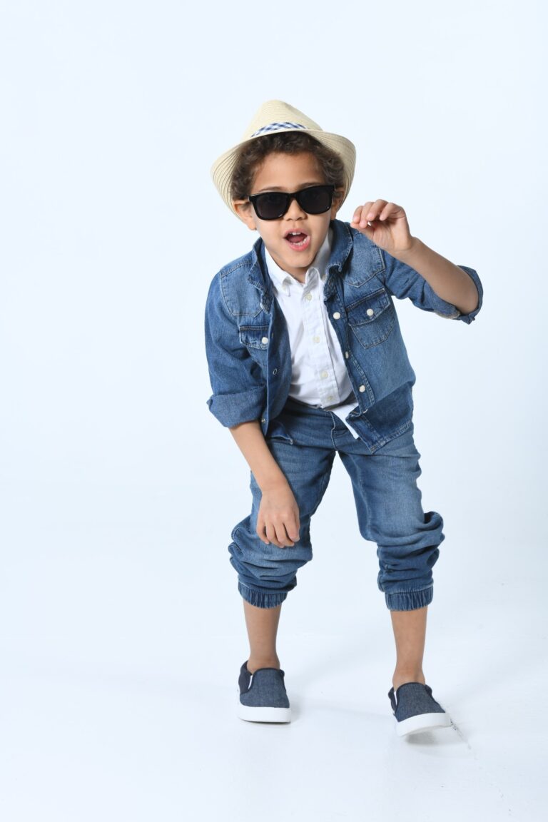 Young boy wearing glasses and a vest in a fashion-style pose