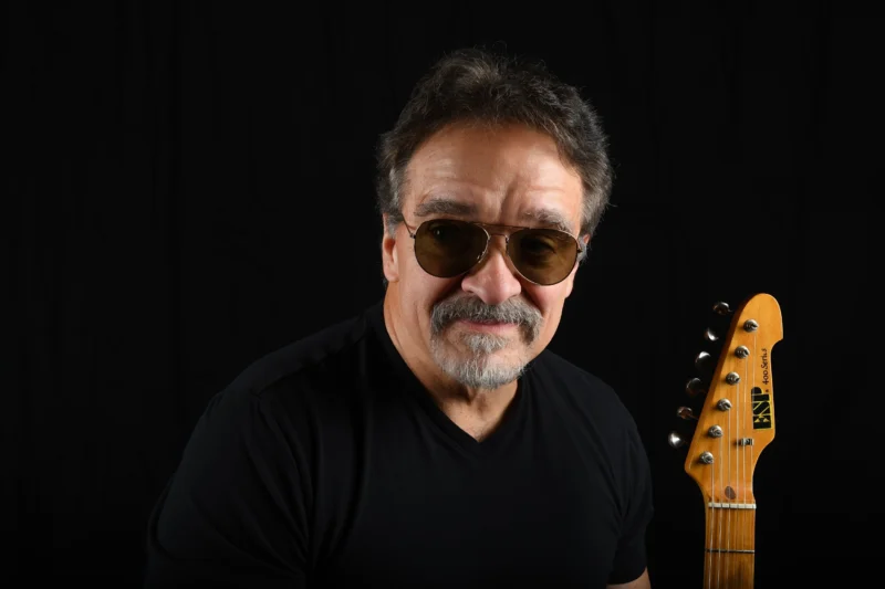Studio portrait of a musician holding a guitar