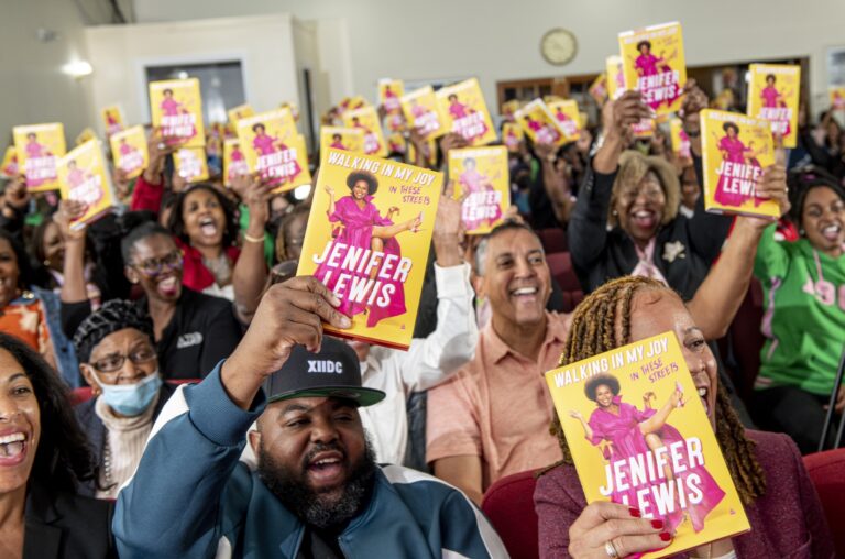 Crowd holding yellow books