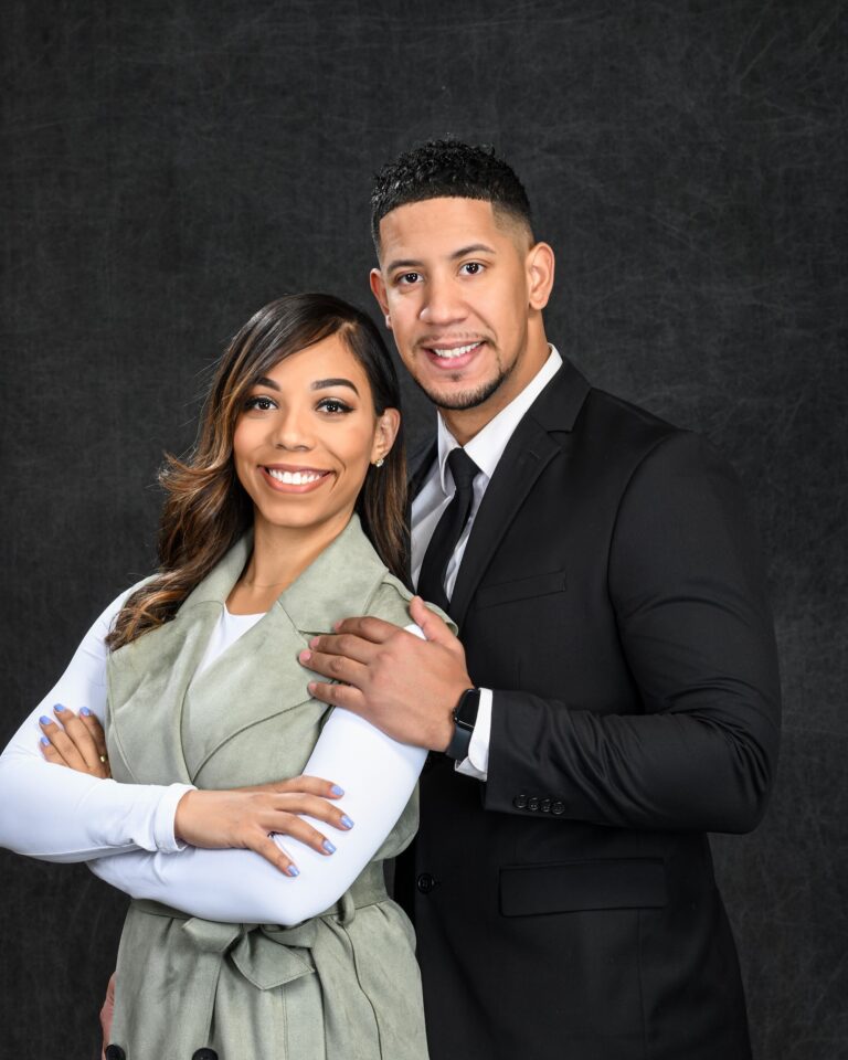Expectant couple posed with hands on the woman's belly
