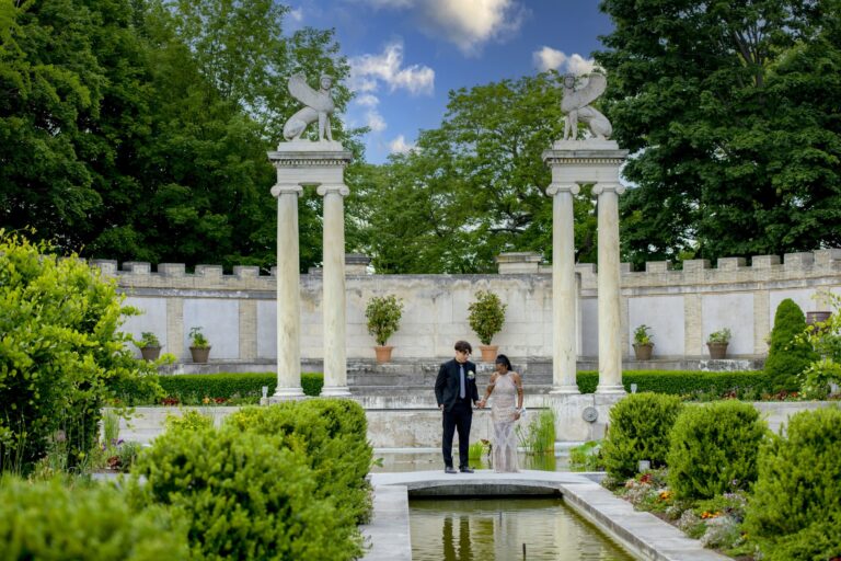Formal couple portrait in an ornamental garden with white columns