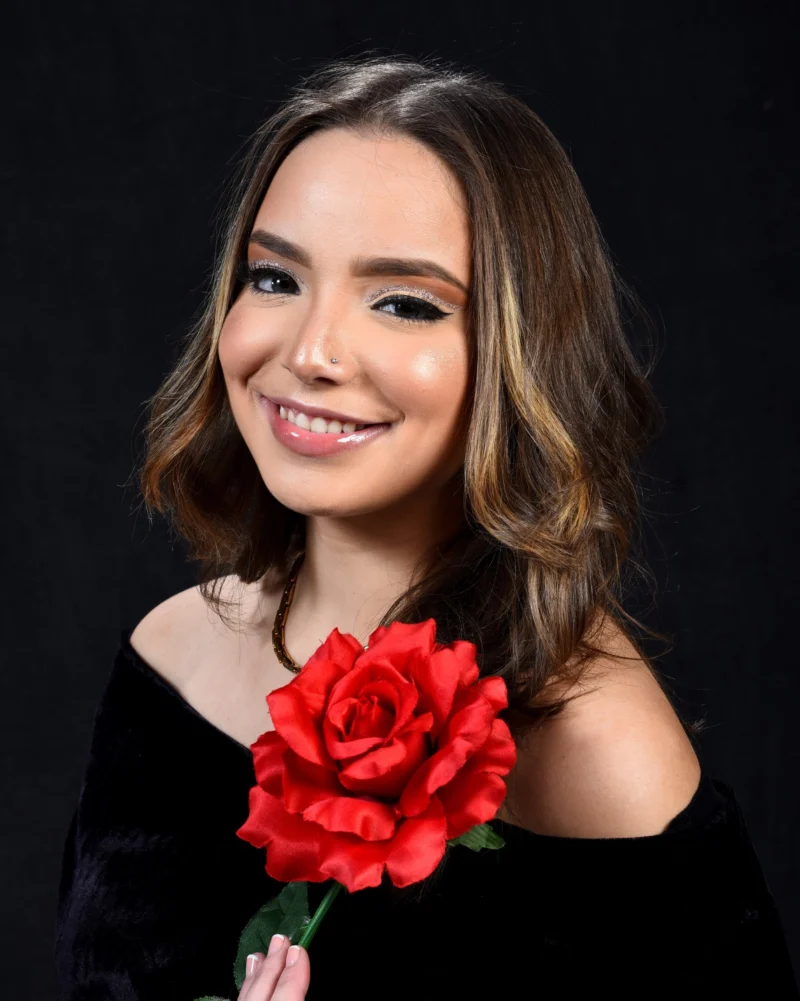 Studio portrait of a woman with a red flower