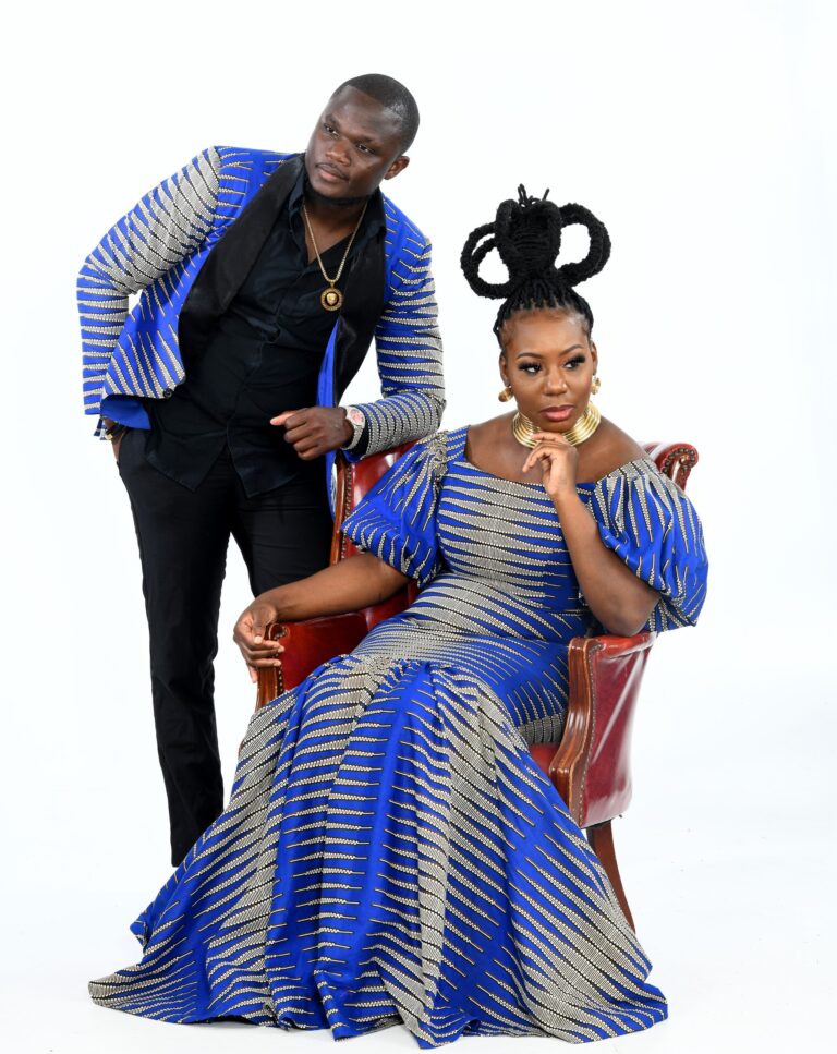 Seated pregnant woman beside a standing man, both in blue and yellow attire