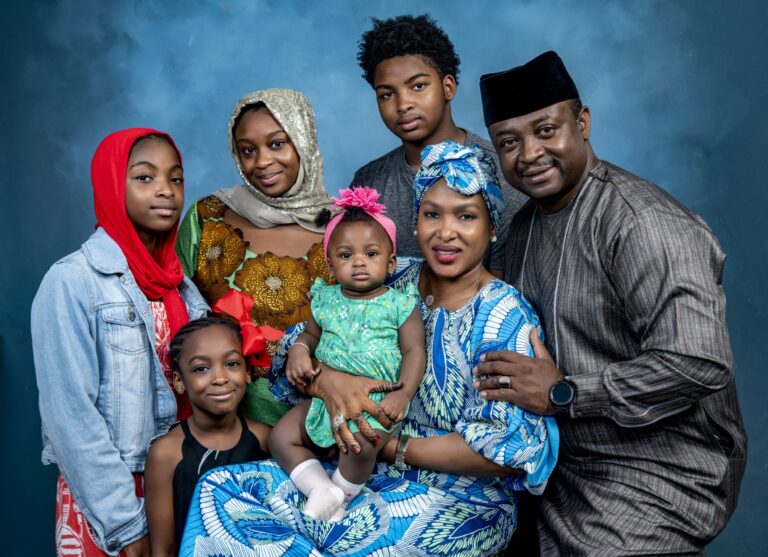 Multigenerational family posed against a blue studio backdrop