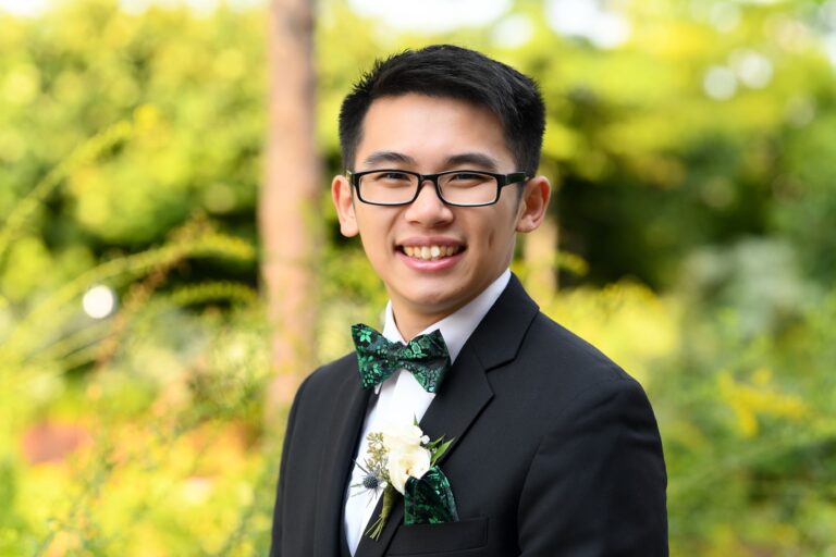 Man outdoors wearing bowtie and boutonniere