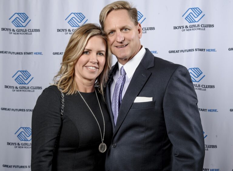 Couple posing at a Boys & Girls Club branded backdrop