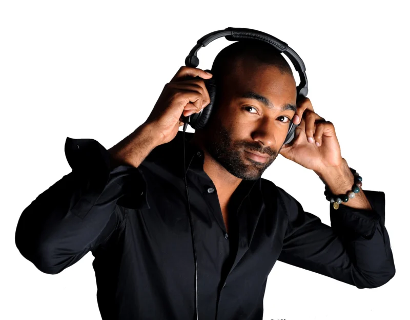 Studio portrait of a man holding headphones against a white background