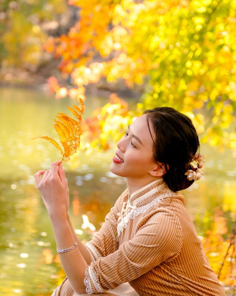 Outdoor portrait among golden autumn leaves