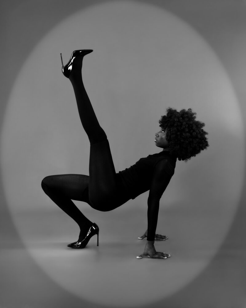 Monochrome studio portrait balancing with one leg raised