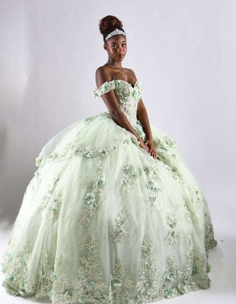 Standing studio portrait in a pale green ball gown and tiara