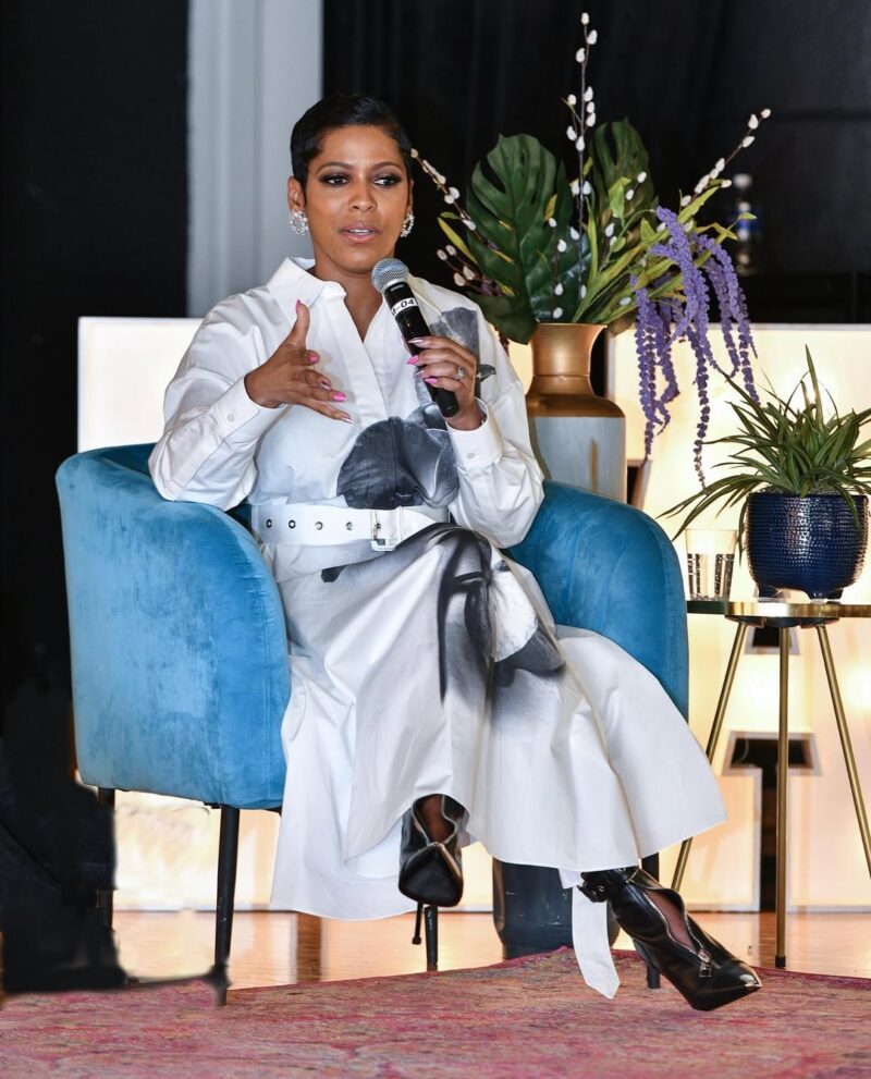 Branding portrait of a woman in a white outfit seated in a blue chair