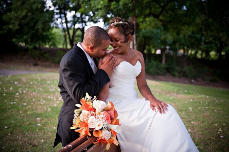 Groom kissing the bride on her shoulder during an outdoor wedding portrait