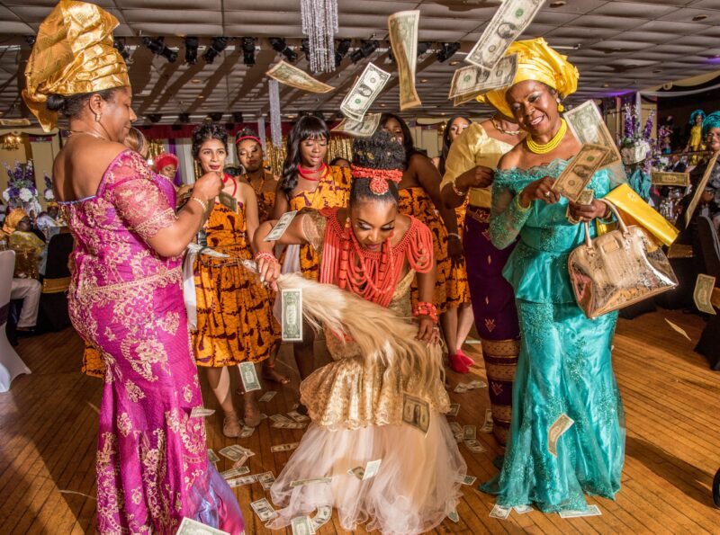 Wedding celebration with guests in colorful attire gathered around a seated bride